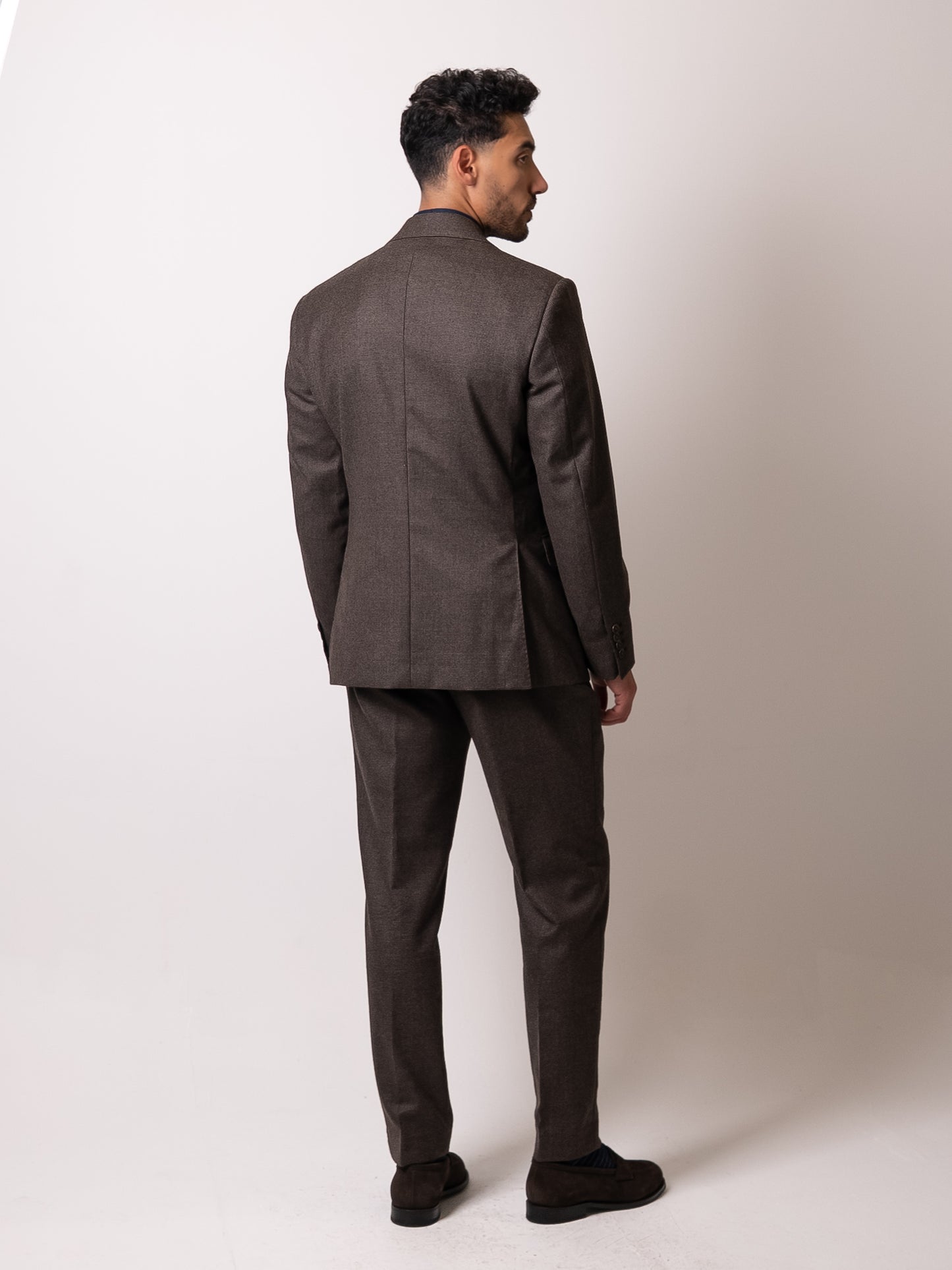 Back view of the deep brown houndstooth suit, showcasing the trousers’ double pleats and clean rear profile