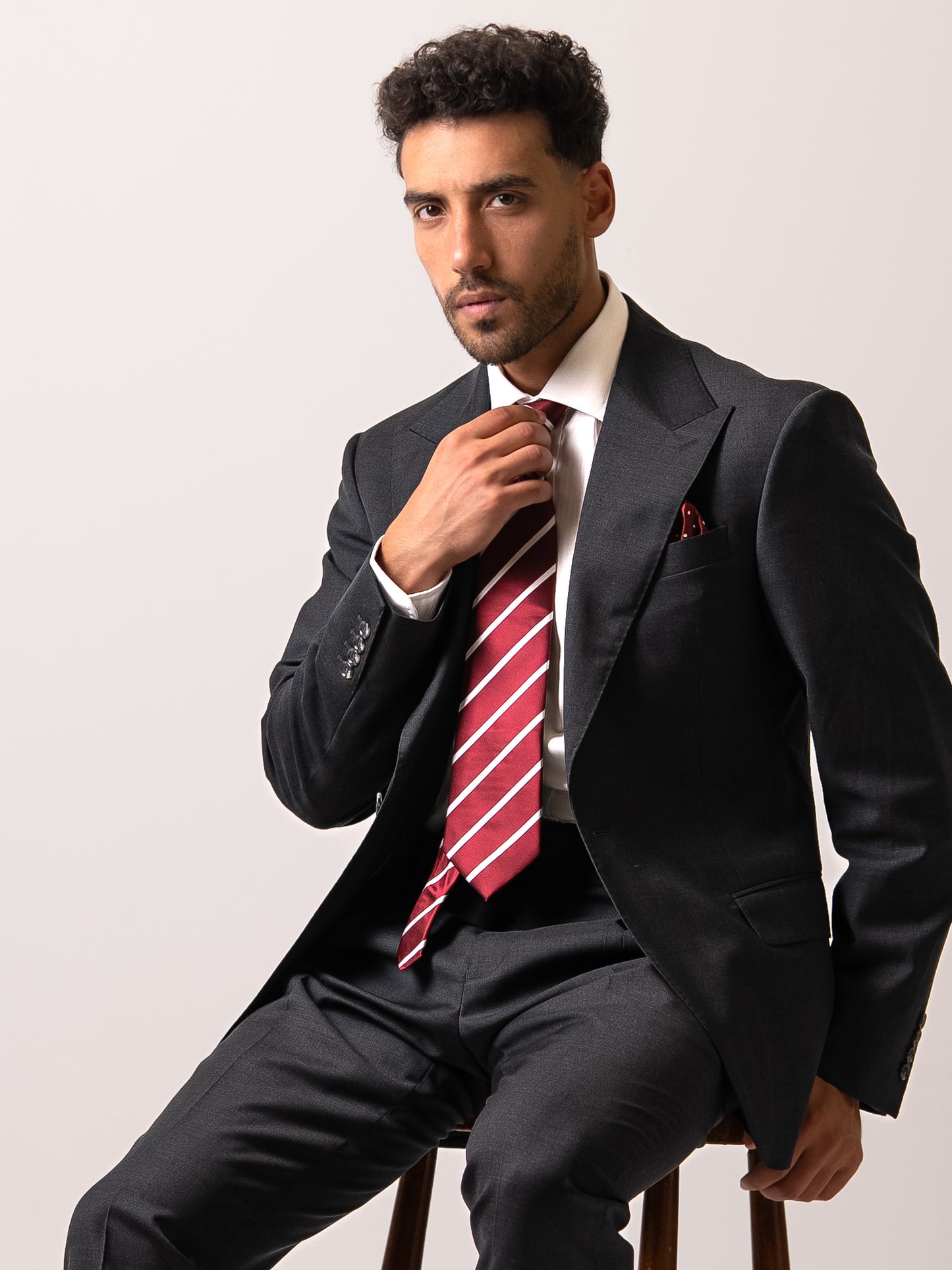 Close-up of functional cuff buttons on a dark sharkskin grey suit. A hallmark of true tailoring, precision, and understated craftsmanship. 