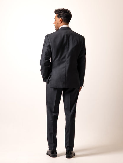 Back view of made-to-measure dark sharkskin grey trousers. Showcasing the refined back pocket, double pleats, and uninterrupted silhouette of Aster Legacy’s Gurkha-inspired cut.