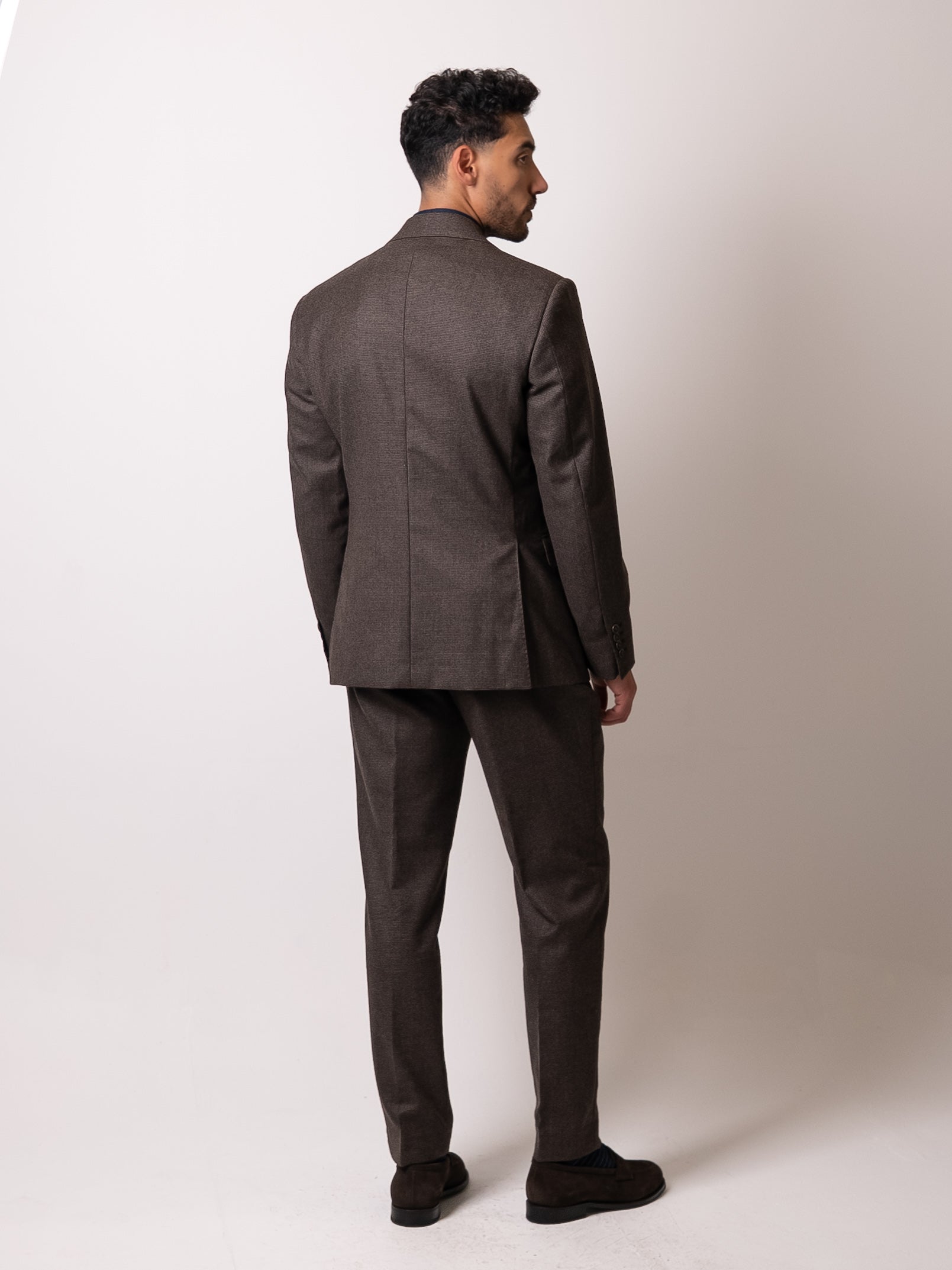 Back view of the deep brown houndstooth suit, showcasing the trousers’ double pleats and clean rear profile