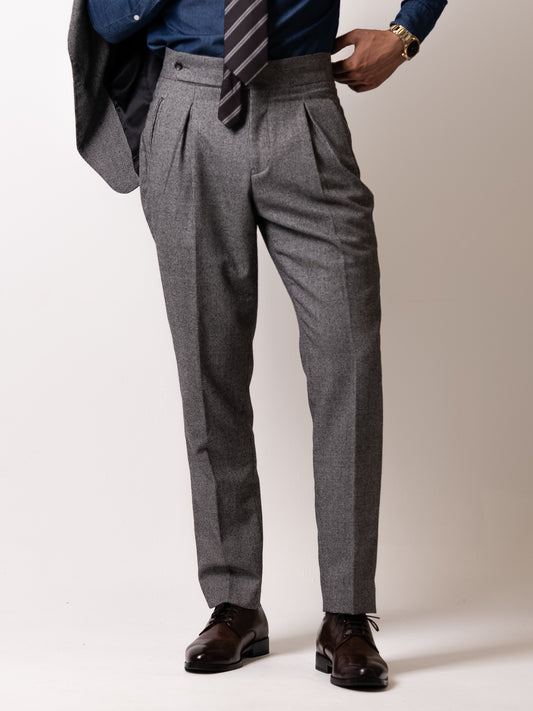 Low-angle view of the light grey houndstooth trousers — clean break, elegant fall, and precise length tailored to complement refined footwear.