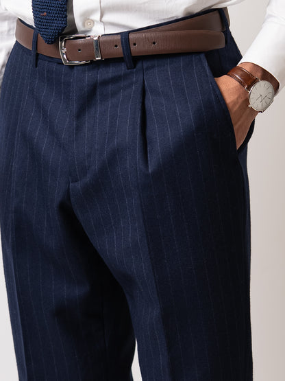Close-up of the refined side pocket on chalk stripe Gurkha trousers, paired with a brown leather belt subtle detailing that preserves uninterrupted form.