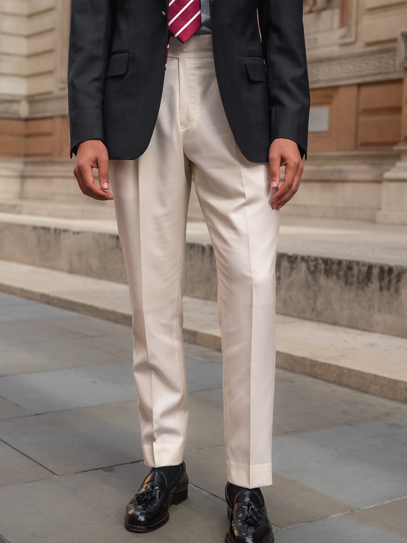 White trousers paired with a dark grey sharkskin blazer