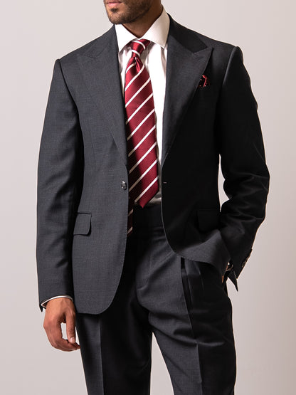 A man stand wearing a made-to-measure dark Sharkskin Grey Suit
