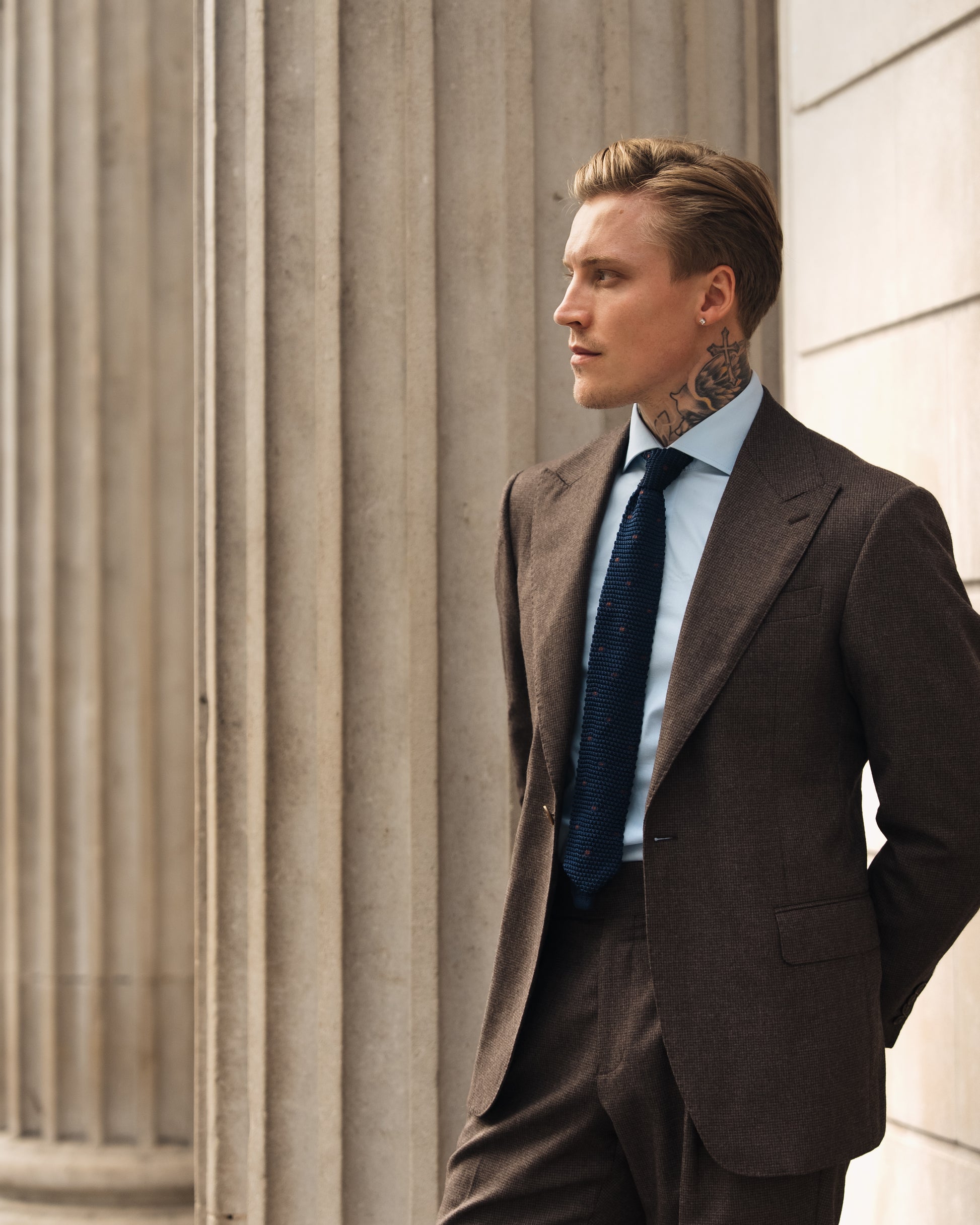 Close-up of the wide peak lapel on a made-to-measure deep brown houndstooth suit.